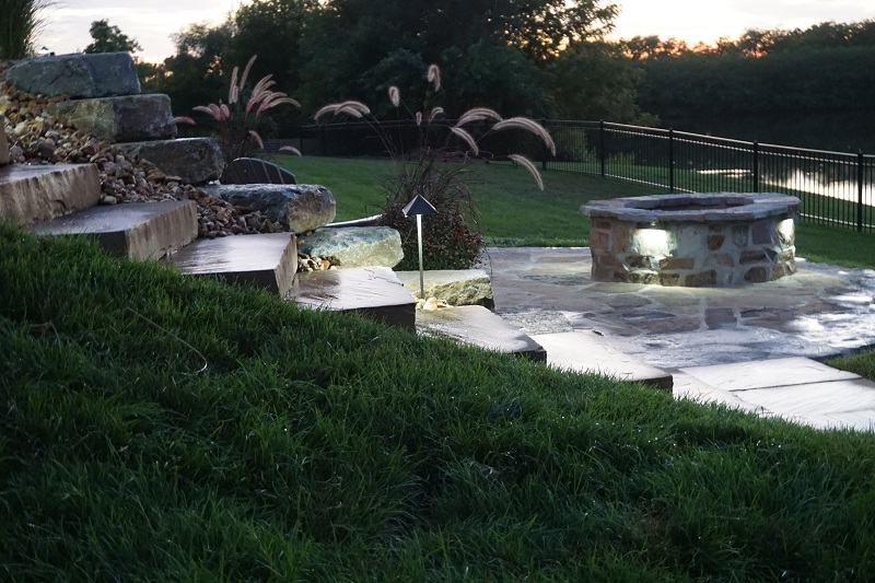 outdoor-lighting-upgrade-your-home-kohler-lawn-pavers-retaining-wall-firepit